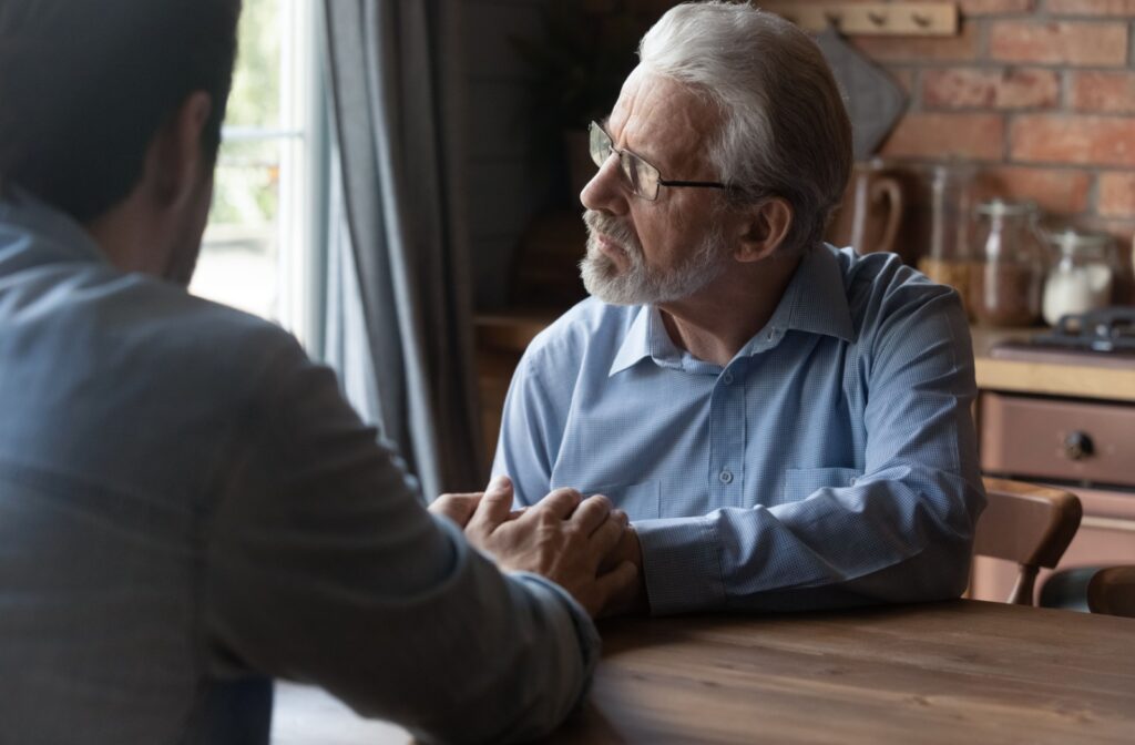 A senior and their adult child chatting about the need to transition to a memory care community.