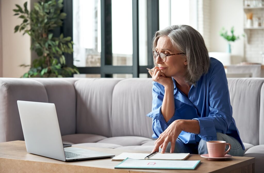 A senior adult looks up local senior living communities on their laptop as they decide which personal care community is best for them.