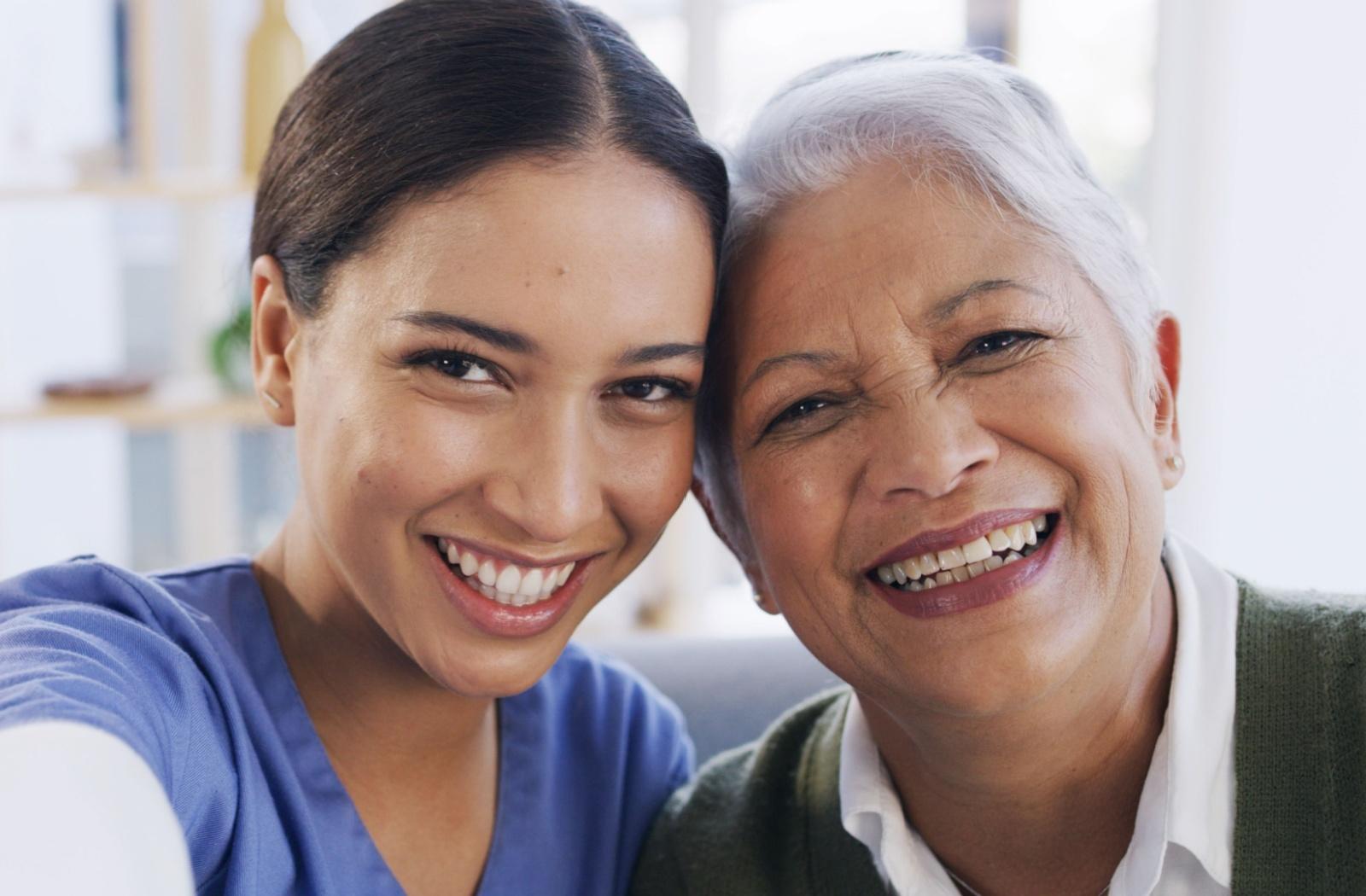 a senior and their younger child smile at the camera