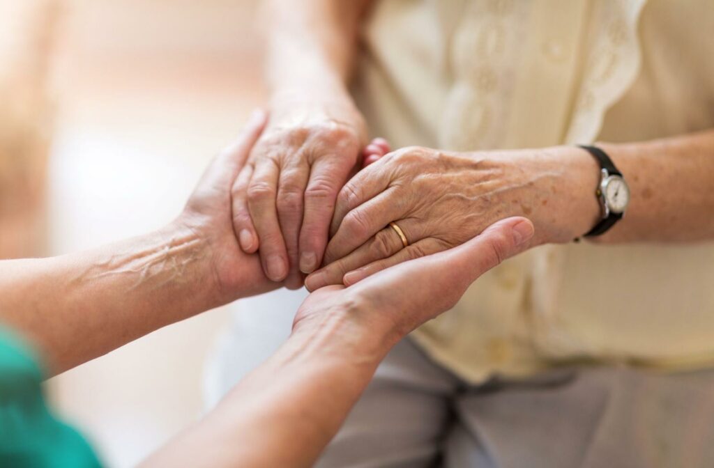 senior hands being held by younger hands in a closeup